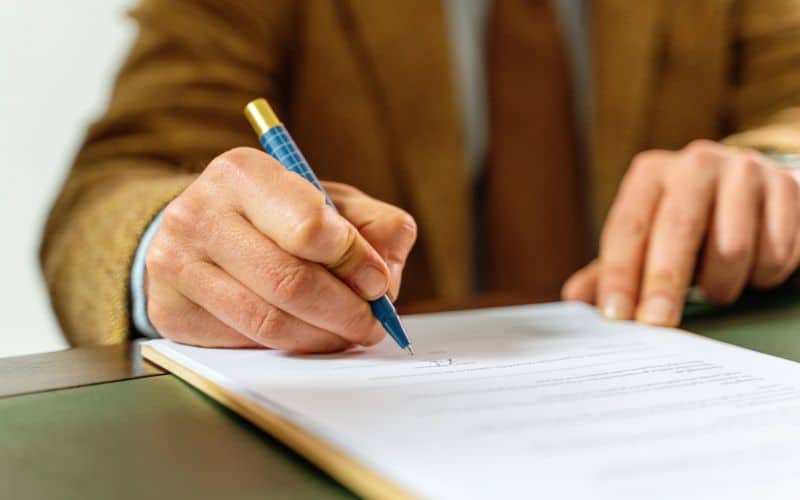 uomo che firma contratto