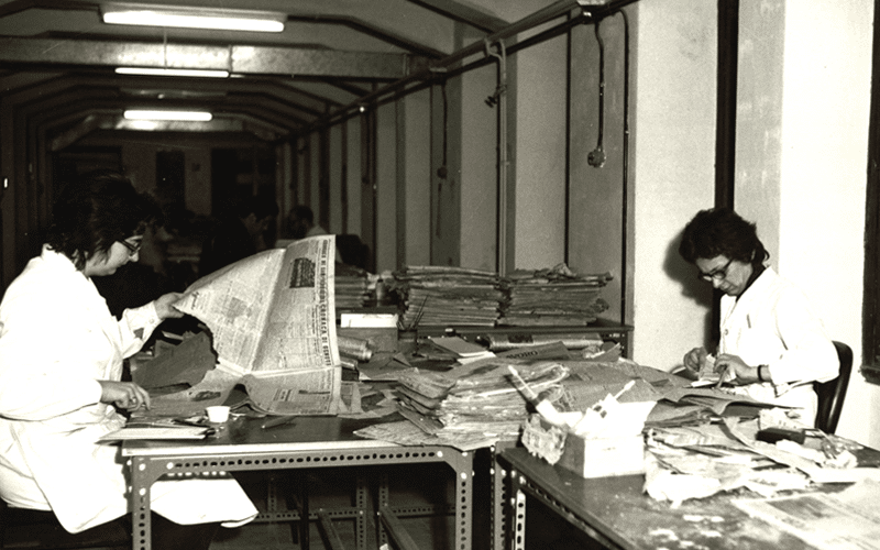 immagine bianco e nero di due donne sedute che lavorano su dei giornali